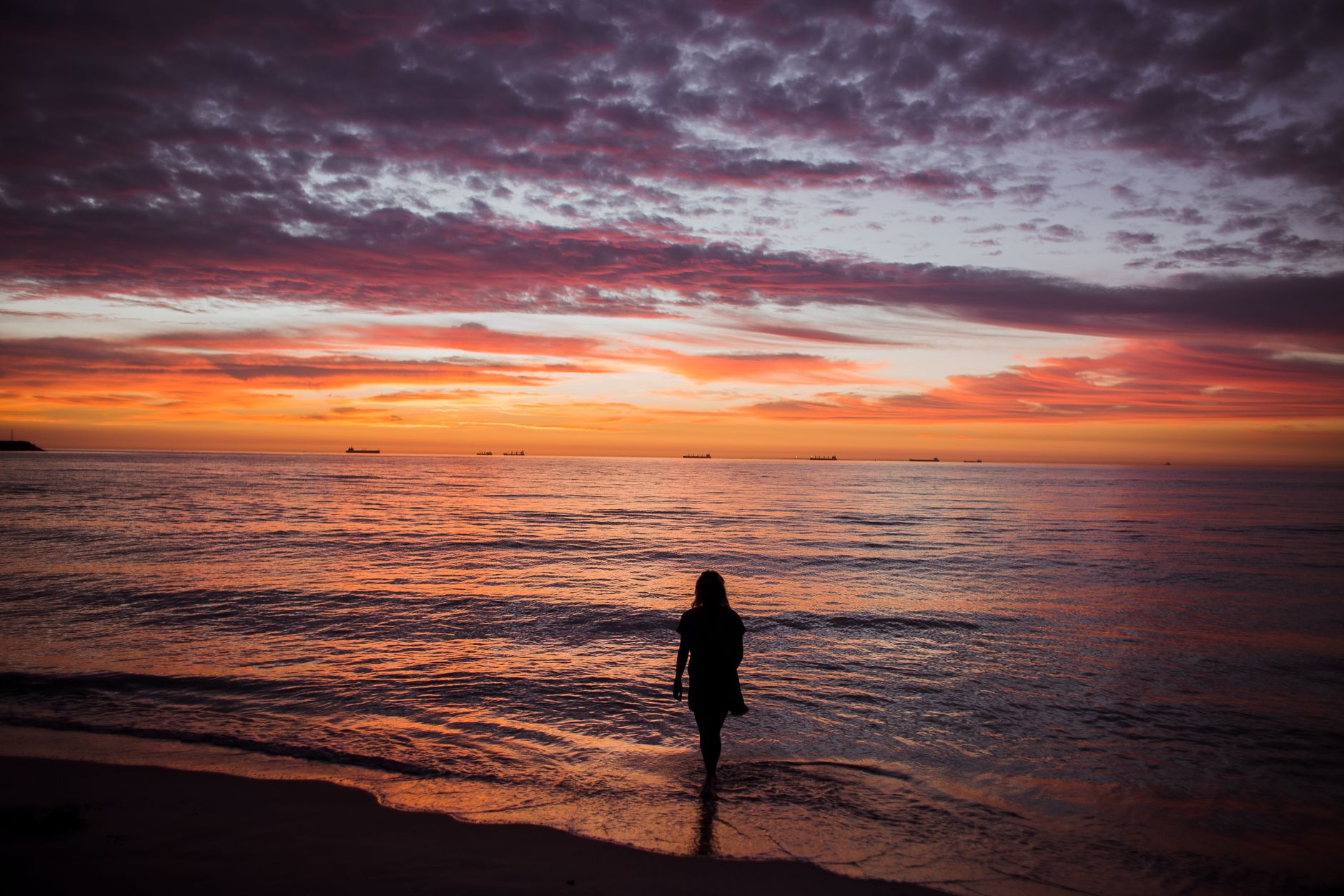 a silhouette of a woman on the shore
